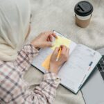 Studentka w hijabie planuje naukę do matury przy laptopie na dworze