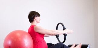 Sport w ciąży co wolno a czego unikać ranking bezpiecznych aktywności konsultowanych z fizjoterapeutami Kobieta w ciąży ćwiczy pilates z ringiem i piłką na siłowni