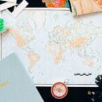 Mapa świata, kompas i planner na stole do planowania podróży