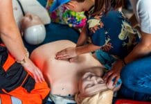 Dziecko ćwiczy resuscytację na fantomie podczas szkolenia ratunkowego